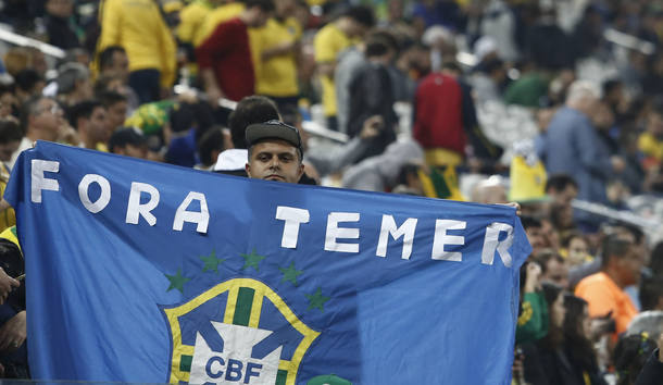 A fan protests against Brazil's interim president Michel Temer during the Rio 2016 Olympic Games men's football quarterfinal match Brazil vs Colombia at the Corinthians Arena, in Sao Paulo, Brazil, on August 13, 2016. / AFP PHOTO / Miguel SCHINCARIOL